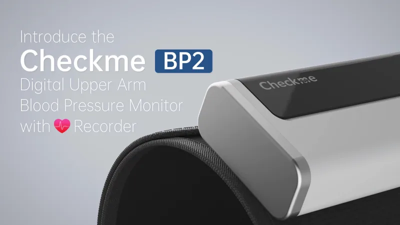 Checkme BP2A blood pressure monitor next to a smartphone showing the ViHealth app