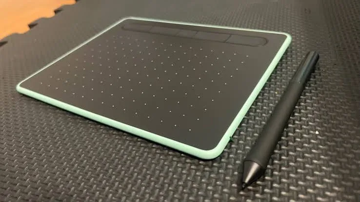 Black Wacom Intuos tablet with a pale green edge and a black stylus beside it